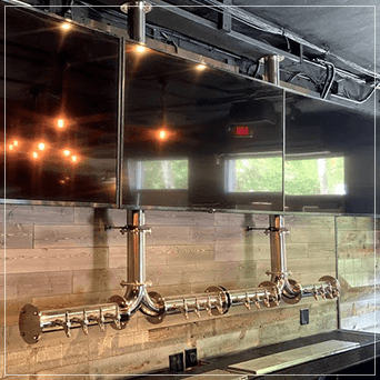Hanging draft beer towers hanging from the ceiling with TVs.