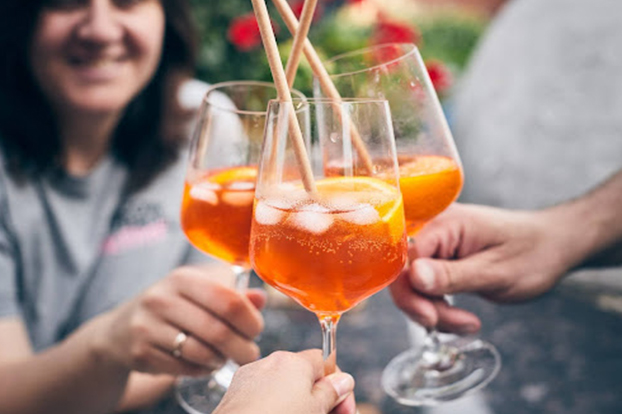 A group of people saying cheers with their prosecco cocktail recipes.