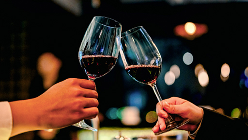People clinking glasses of wine in celebration of November wine holidays.